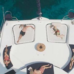Luxury Sailing & Motor Catamaran sunbathing on the foredeck